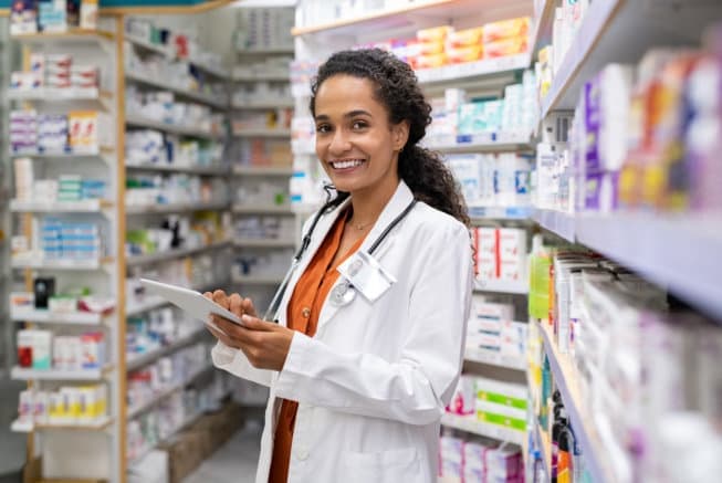 Young mixed race pharmacist using digital tablet