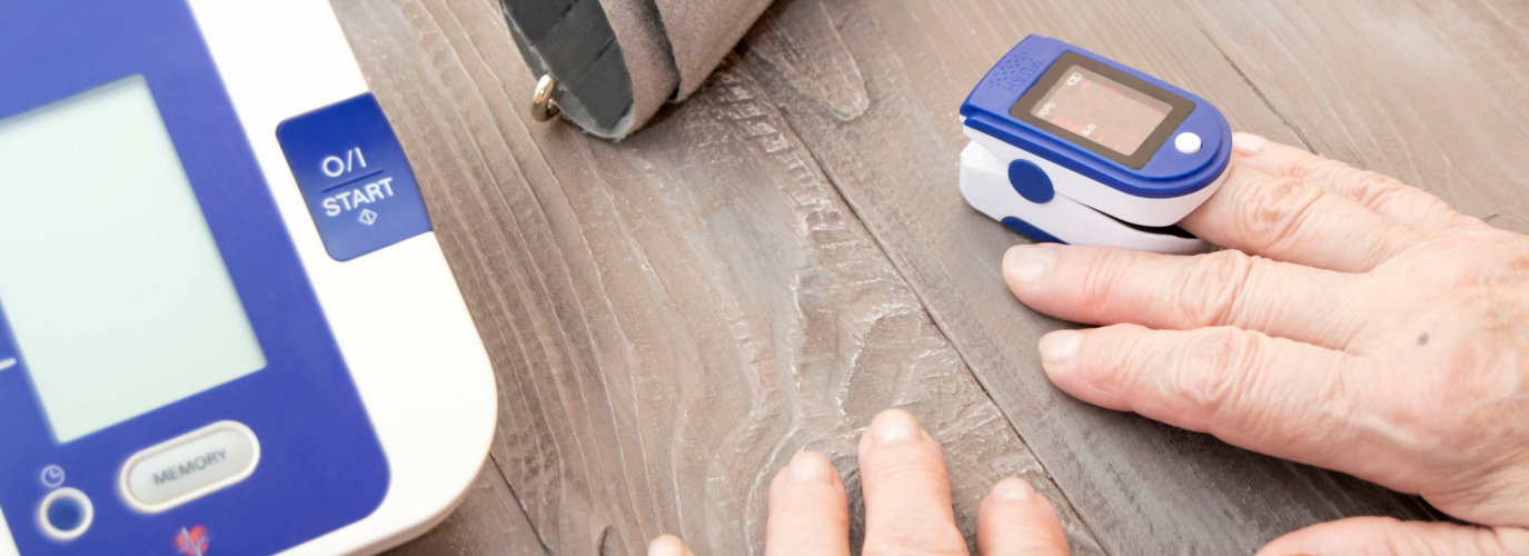 The hands of an elderly person measuring the oxygen level in the blood with a pulse oximeter